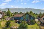 Experience breathtaking mountain views from this stunning blue home, featuring a spacious deck perfect for entertaining and large windows that flood the interior with natural light.