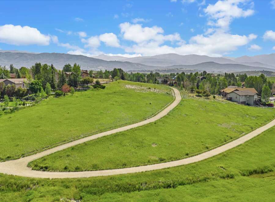 Discover your dream home nestled in a picturesque landscape with rolling green hills and majestic mountain views.