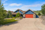 Discover this charming blue home featuring a vibrant red garage door and natural stone accents.