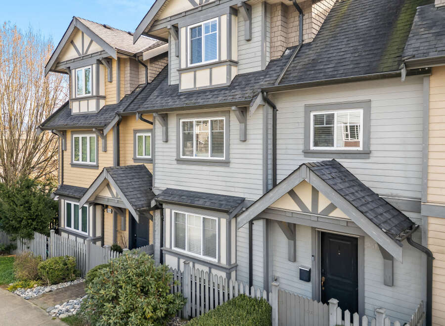 Discover the charm of this stunning townhome, featuring a beautifully designed exterior with a mix of siding and a welcoming front porch.