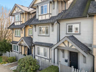 Discover the charm of this stunning townhome, featuring a beautifully designed exterior with a mix of siding and a welcoming front porch.