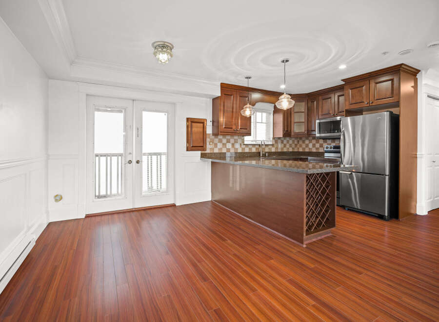 This stunning kitchen boasts a modern design with sleek stainless steel appliances and rich, dark wood cabinetry.