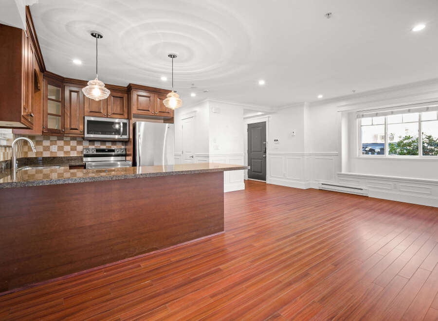 This stunning kitchen boasts rich wood cabinetry, stainless steel appliances, and a sleek granite countertop.