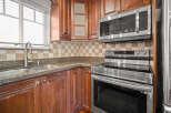 This stunning kitchen boasts beautiful wooden cabinetry and modern stainless steel appliances.