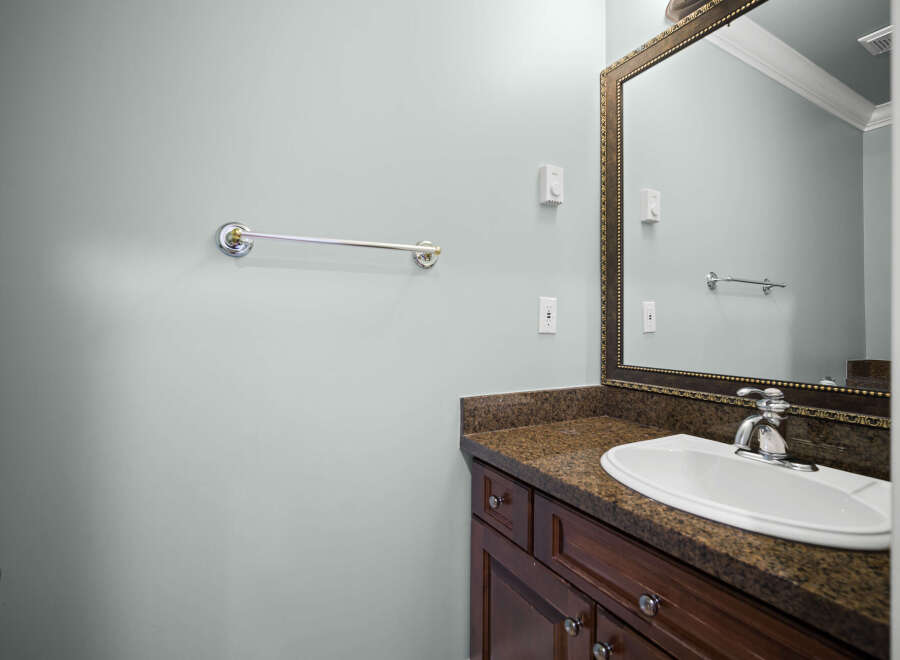 This bathroom features a stylish vanity with a granite countertop and dark wood cabinetry.