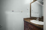 This bathroom features a stylish vanity with a granite countertop and dark wood cabinetry.