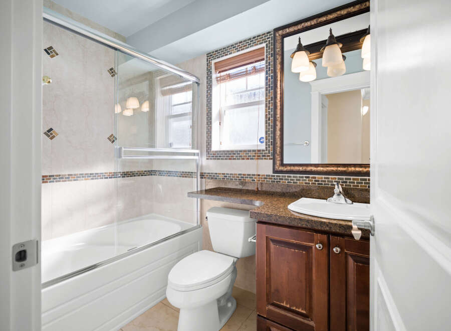Step into this beautifully designed bathroom, featuring a modern glass shower enclosure and elegant tile work.