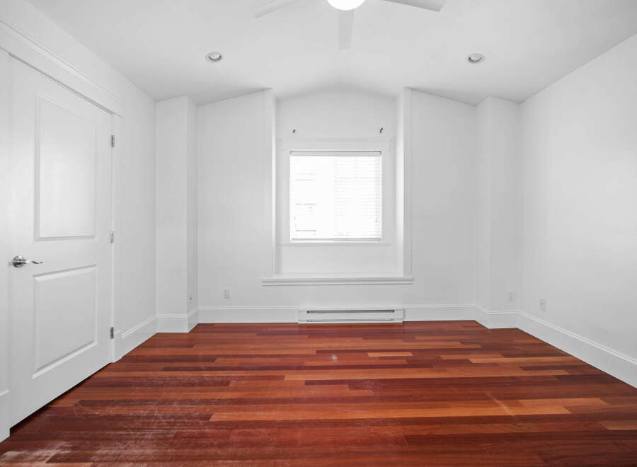 This stunning room boasts a bright and airy atmosphere with its pristine white walls and ample natural light.