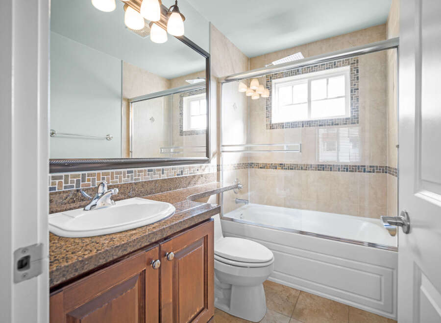 This beautiful bathroom features a modern design with a sleek vanity and a spacious bathtub.