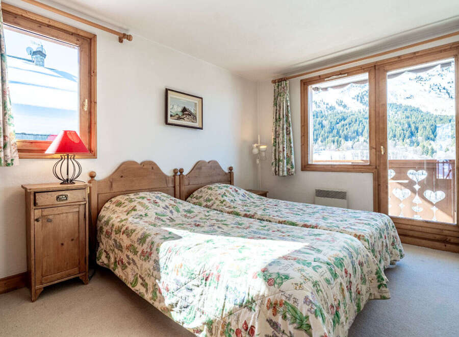 This charming bedroom offers a cozy retreat with its two twin beds and floral bedding.