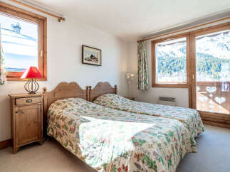 This charming bedroom offers a cozy retreat with its two twin beds and floral bedding.