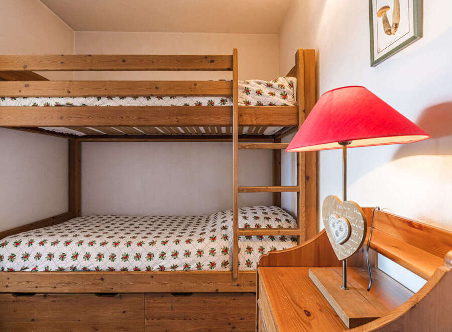 Discover the charm of this cozy bedroom featuring a sturdy wooden bunk bed, perfect for accommodating guests or family members.