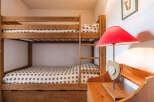 Discover the charm of this cozy bedroom featuring a sturdy wooden bunk bed, perfect for accommodating guests or family members.