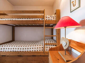 Discover the charm of this cozy bedroom featuring a sturdy wooden bunk bed, perfect for accommodating guests or family members.