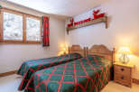 This cozy bedroom features two twin beds with a charming quilt design, perfect for a comfortable stay.
