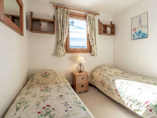 This charming bedroom features two twin beds with floral bedding, perfect for a cozy retreat.