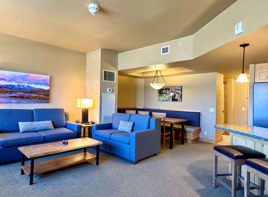 This stunning property features a spacious living area with comfortable blue sofas and a stylish coffee table.
