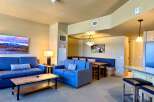 This stunning property features a spacious living area with comfortable blue sofas and a stylish coffee table.