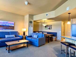 This stunning property features a spacious living area with comfortable blue sofas and a stylish coffee table.