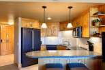 This stunning kitchen boasts beautiful wooden cabinetry, a sleek black refrigerator, and a stylish granite countertop.
