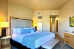 This luxurious bedroom features a king-sized bed with plush bedding and a stylish blue and white striped bed runner.