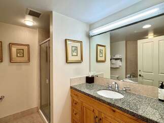 Step into this beautifully designed bathroom, featuring a granite countertop and wooden cabinetry that exudes timeless elegance.