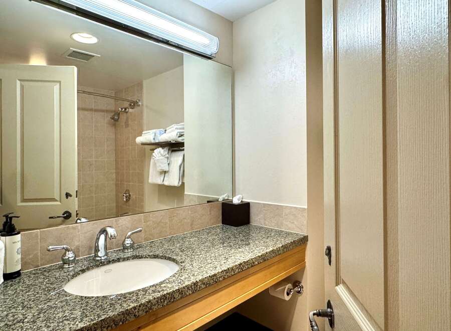 This bathroom features a granite countertop with a sink and faucet, providing a sleek and modern look.