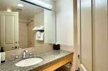 This bathroom features a granite countertop with a sink and faucet, providing a sleek and modern look.