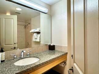 This bathroom features a granite countertop with a sink and faucet, providing a sleek and modern look.