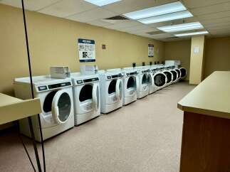 This laundry room features multiple Maytag dryers, perfect for handling large loads of laundry.