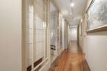 Step into this inviting hallway, showcasing beautiful hardwood floors that extend throughout the space.