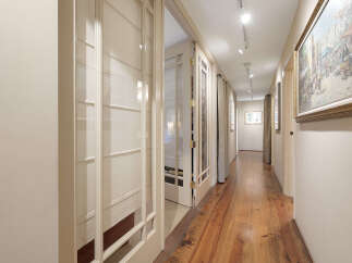 Step into this inviting hallway, showcasing beautiful hardwood floors that extend throughout the space.