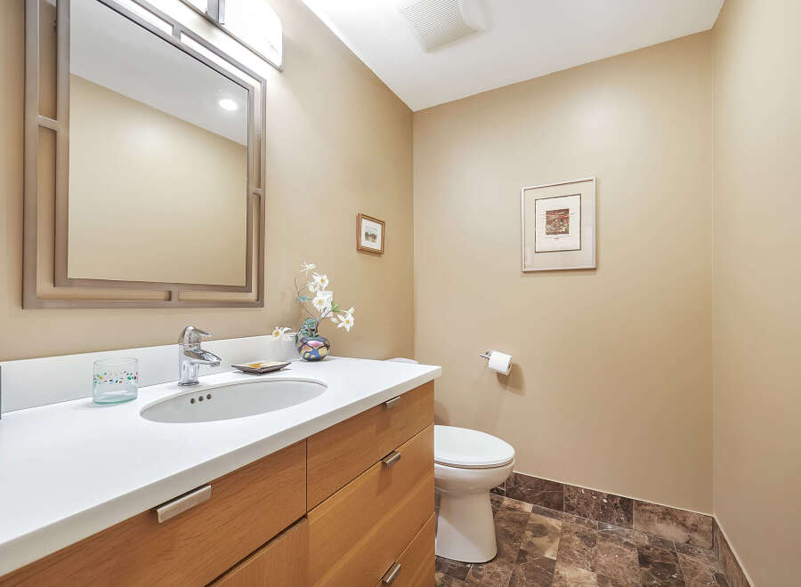 This stunning bathroom features a modern design with a sleek vanity and a stylish mirror.