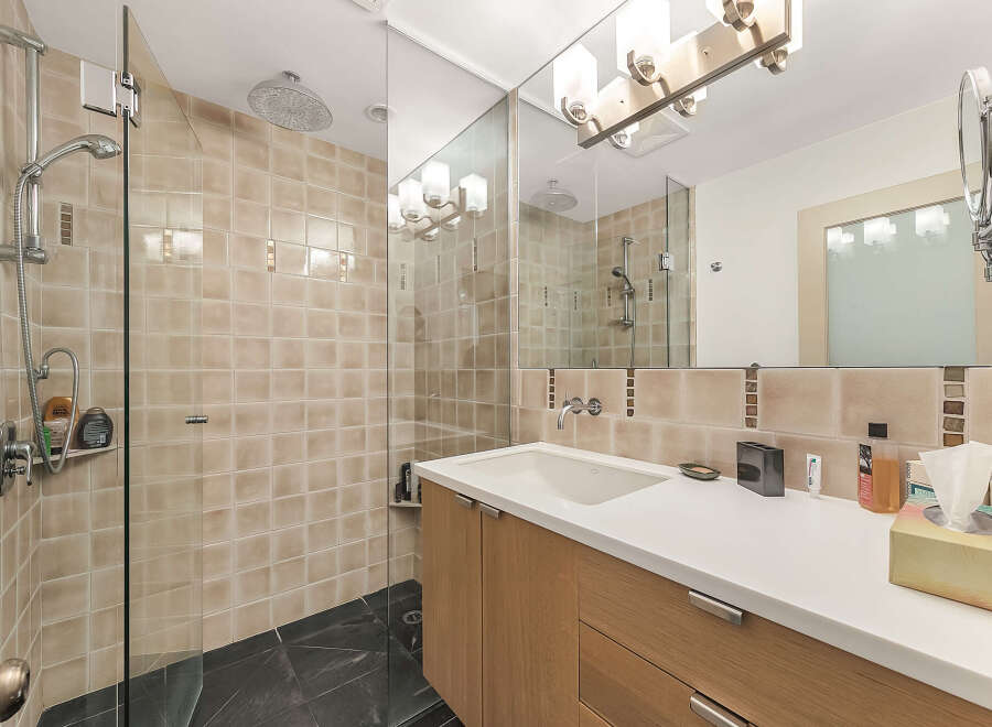 Step into a modern bathroom oasis! This stunning space features a sleek glass shower enclosure, complemented by elegant tile work and contemporary fixtures.