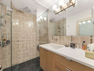 Step into a modern bathroom oasis! This stunning space features a sleek glass shower enclosure, complemented by elegant tile work and contemporary fixtures.
