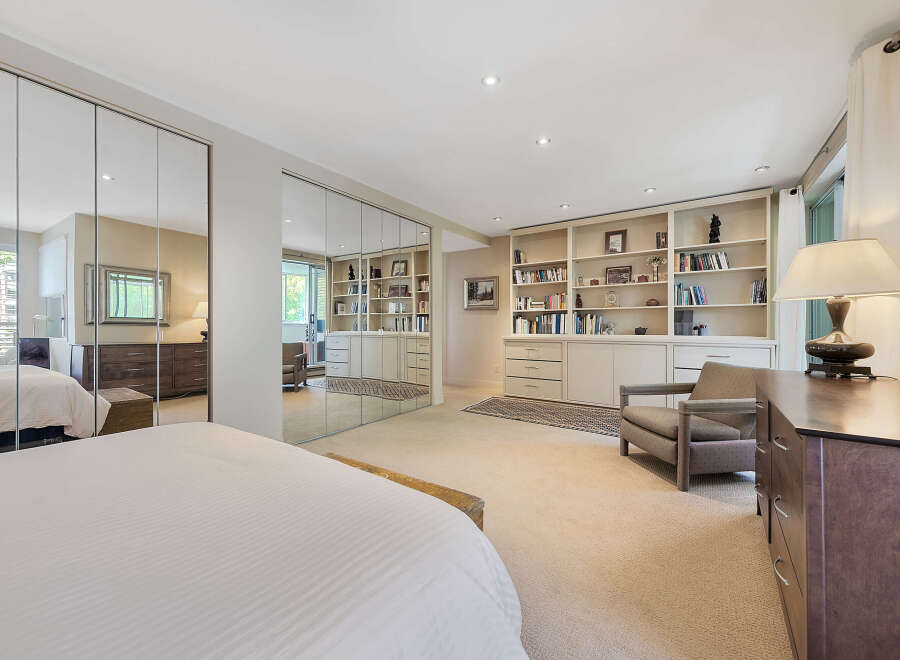 Step into luxury with this stunning bedroom featuring expansive mirrored closet doors, creating a sense of spaciousness and elegance.