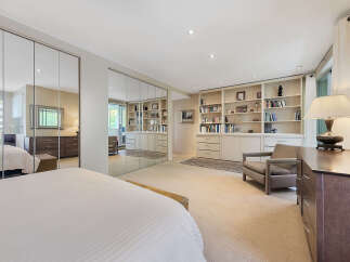 Step into luxury with this stunning bedroom featuring expansive mirrored closet doors, creating a sense of spaciousness and elegance.