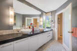 Step into luxury with this stunning bathroom, featuring a sleek black countertop and modern white cabinetry.