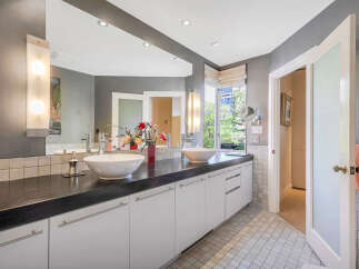 Step into luxury with this stunning bathroom, featuring a sleek black countertop and modern white cabinetry.