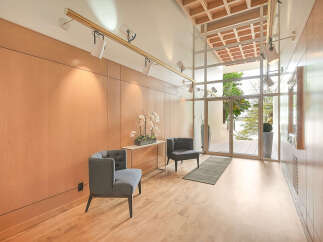 Step into luxury with this stunning entryway, featuring sleek wooden paneling and modern track lighting.