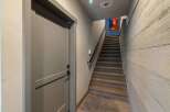Step into this inviting entryway featuring a stylish staircase and a modern door.