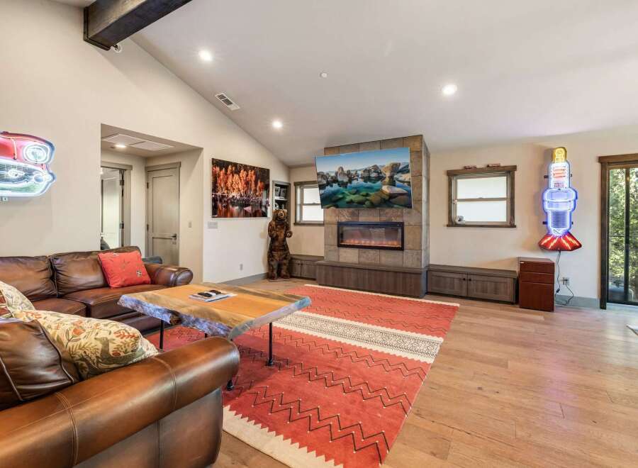 Step into luxury with this stunning living room, featuring a cozy fireplace and a large TV perfect for entertainment.