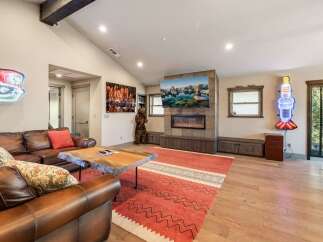 Step into luxury with this stunning living room, featuring a cozy fireplace and a large TV perfect for entertainment.