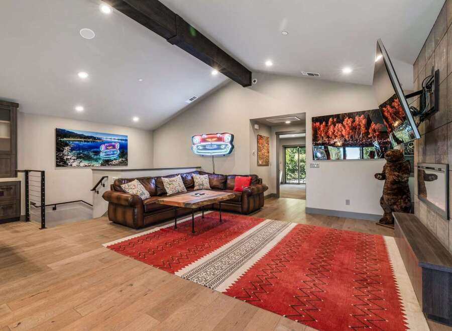 Step into luxury with this stunning living space, featuring a cozy leather sofa and a striking red rug that adds warmth and character.