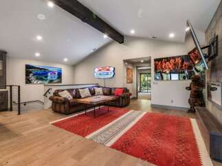 Step into luxury with this stunning living space, featuring a cozy leather sofa and a striking red rug that adds warmth and character.
