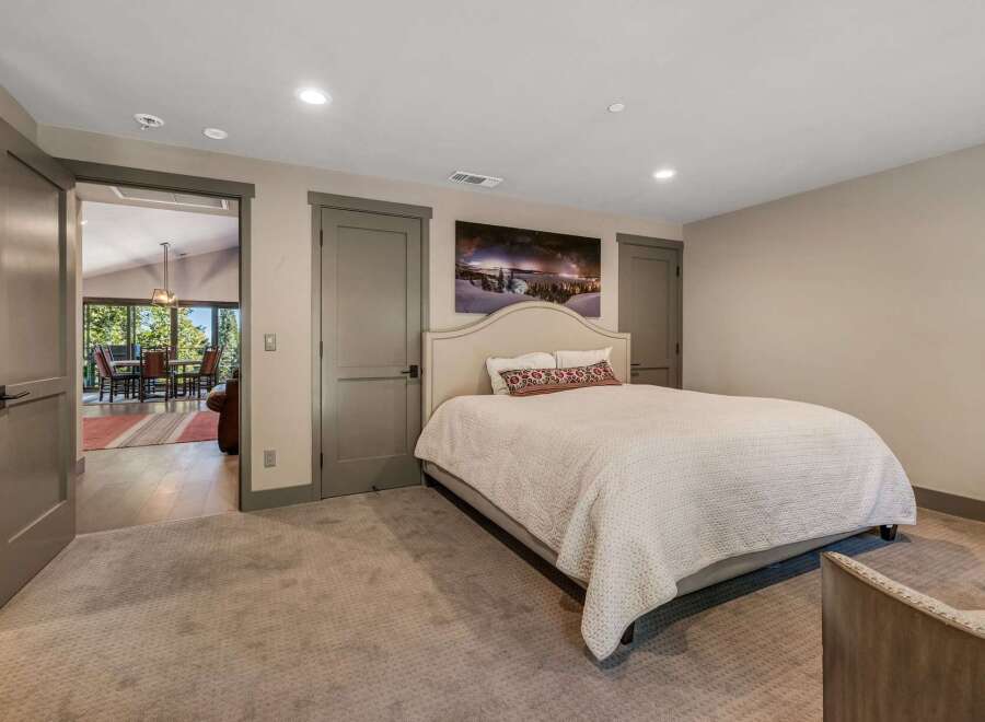 Step into this inviting bedroom, featuring a cozy bed and a stunning landscape artwork.