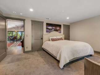 Step into this inviting bedroom, featuring a cozy bed and a stunning landscape artwork.