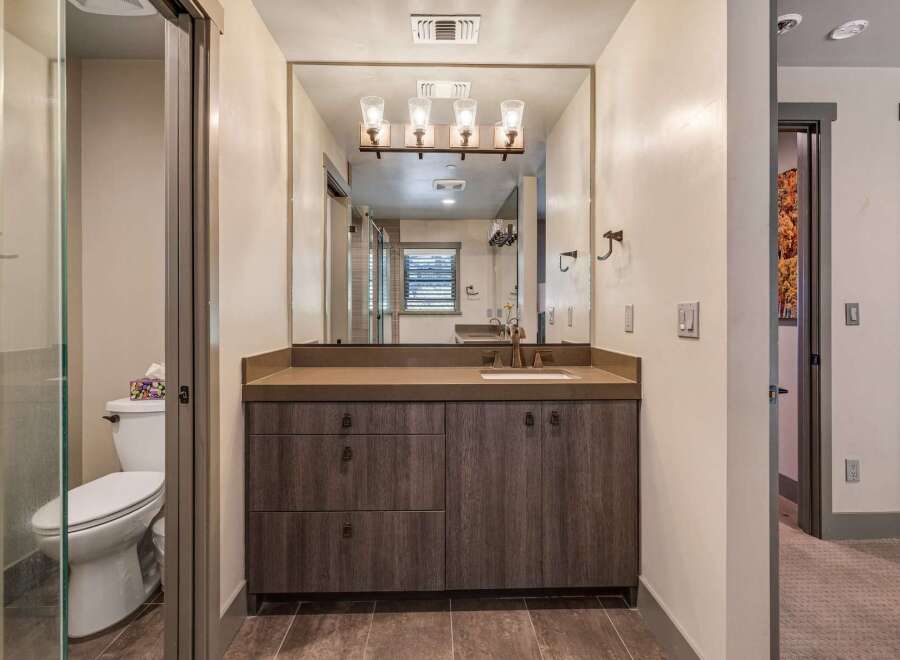 Step into luxury with this stunning bathroom! Featuring a modern vanity with ample storage, a sleek countertop, and a large mirror, this space is designed for both style and functionality.