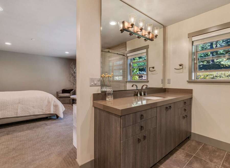 Step into luxury with this stunning bathroom, featuring a sleek vanity and a large mirror that reflects natural light.