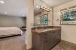 Step into luxury with this stunning bathroom, featuring a sleek vanity and a large mirror that reflects natural light.